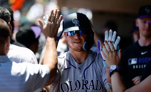 Colorado Rockies' Hunter Goodman is greeted by teammates after hitting a two-run home run during the first inning of a baseball game against the Athletics, Sunday, June 14, 2026, in Las Vegas. (AP Photo/Caroline Brehman)