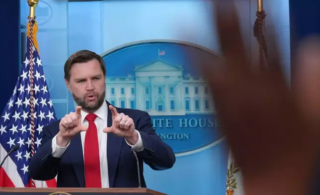 A reporter raises a hand to ask a question as Vice President JD Vance speaks in the James Brady Press Briefing Room at the White House, Thursday, June 18, 2026, in Washington. (AP Photo/Jacquelyn Martin)