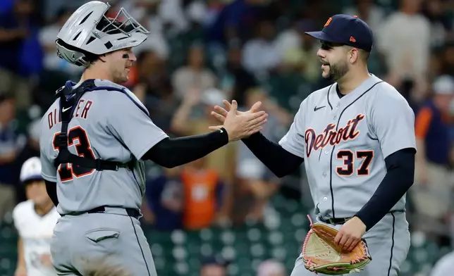 Detroit Tigers catcher Dillon Dingler (13) and closing pitcher Enmanuel de Jesus (37) shake hands after their team defeated the Houston Astros in a baseball game Monday, June 15, 2026, in Houston. (AP Photo/Michael Wyke)