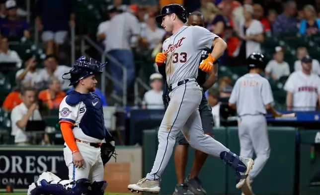 Detroit Tigers' Colt Keith (33) scores on his third home run of a baseball game near Houston Astros catcher Christian Vazquez, left, during the ninth inning of a baseball game Monday, June 15, 2026, in Houston. (AP Photo/Michael Wyke)