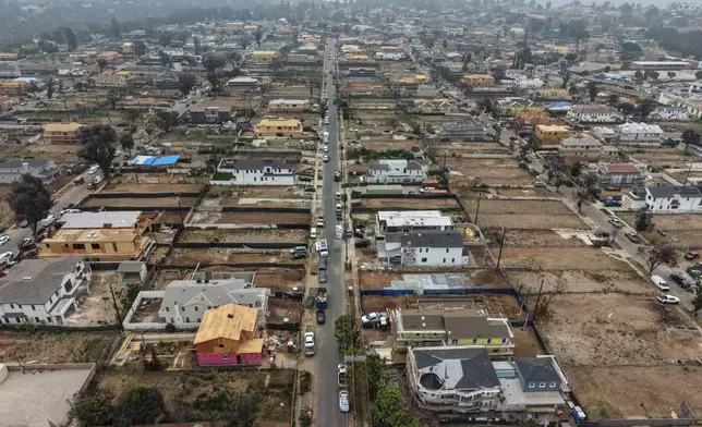 An aerial view shows homes under construction amid empty lots more than a year after the Palisades Fire in the Pacific Palisades neighborhood of Los Angeles, Thursday, June 4, 2026. (AP Photo/Jae C. Hong)