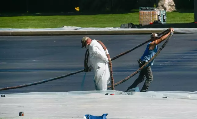 Work continues on the Lincoln Memorial Reflecting Pool, which is covered in a blue coating, ahead of the United States 250th anniversary, Thursday, June 4, 2026, in Washington. (AP Photo/Rod Lamkey, Jr.)