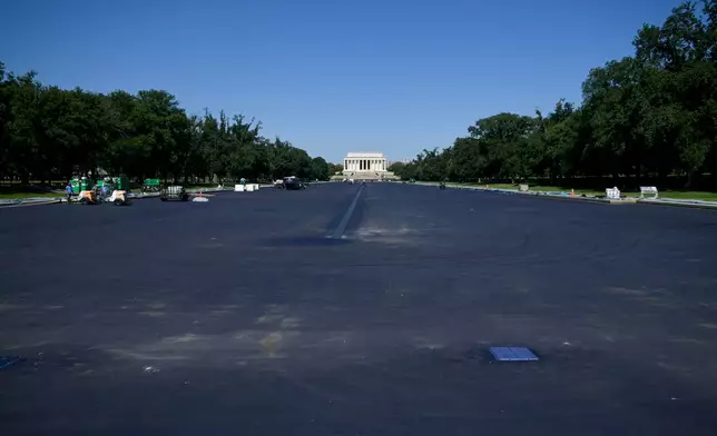 Work continues on the Lincoln Memorial Reflecting Pool, which is covered in a blue protective coating, ahead of the United States 250th anniversary, Thursday, June 4, 2026, in Washington. (AP Photo/Rod Lamkey, Jr.)
