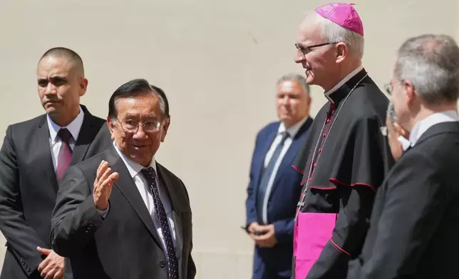 Peru's interim President Jose Maria Balcazar, second left, is welcomed by Archbishop Petar Rajic, Prefect of the Prefecture of the Papal Household, as he arrives in the St. Damasus Courtyard to meet with Pope Leo XIV, at the Vatican, on Thursday, June 18, 2026. (AP Photo/Andrew Medichini)