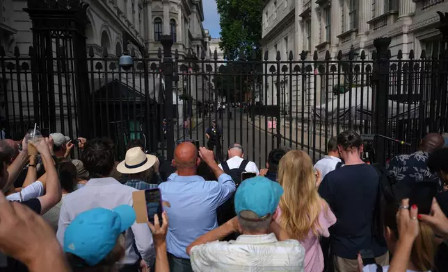 Members of the public watch as Britain's Prime Minister Keir Starmer steps out to speak to the media outside 10 Downing Street in London, Monday, June 22, 2026.(AP Photo/Alastair Grant)
