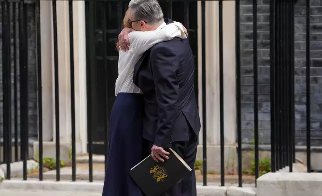 Britain's Prime Minister Keir Starmer hugs his wife Victoria outside 10 Downing Street after speaking to the media in London, Monday, June 22, 2026.(AP Photo/Kin Cheung)