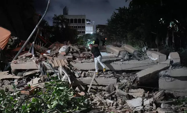 A man jumps on a collapsed building after an earthquake in Caracas, Venezuela, Wednesday, June 24, 2026. (AP Photo/Adrian Naranjo)