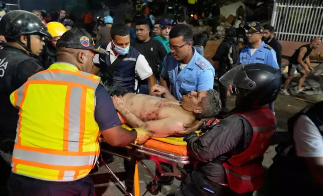 Rescue worker carry an injured man after an earthquake in Caracas, Venezuela, Wednesday, June 24, 2026. (AP Photo/Ariana Cubillos)