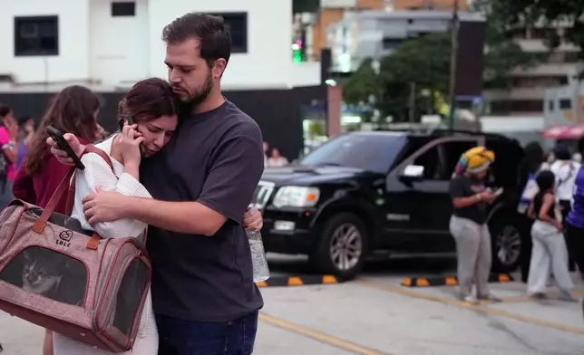 People embrace after an earthquake in Caracas, Venezuela, Wednesday, June 24, 2026. (AP Photo/Ariana Cubillos)