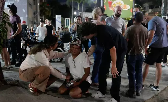 People remain outside their homes after an earthquake in Caracas, Venezuela, Wednesday, June 24, 2026. (AP Photo/Ariana Cubillos)