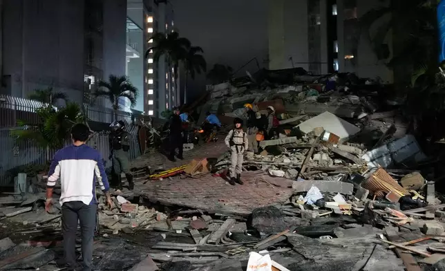 People walk amid debris after an earthquake in Caracas, Venezuela, Wednesday, June 24, 2026. (AP Photo/Ariana Cubillos)