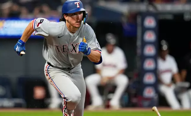 Texas Rangers' Cameron Cauley drops his bat and runs towards first base with a triple, his first major league hit, in the seventh inning of a baseball game against the Cleveland Guardians in Cleveland, Monday, June 29, 2026. (AP Photo/Sue Ogrocki)