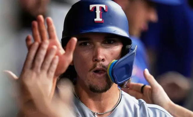 Texas Rangers' Cameron Cauley celebrates in the dugout after scoring in the seventh inning of a baseball game against the Cleveland Guardians in Cleveland, Monday, June 29, 2026. (AP Photo/Sue Ogrocki)