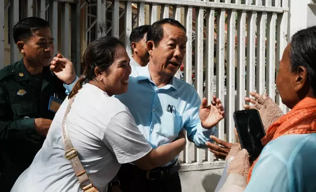 Rong Chhun, a prominent Cambodian opposition politician, center, interacts with his supporters as he leaves a Supreme Court hearing in Phnom Penh, Cambodia, Monday, June 15, 2026. (AP Photo/Heng Sinith)