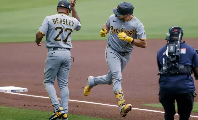 Pittsburgh Pirates' Spencer Horwitz, center, is greeted by third base coach Tony Beasley, left after hitting a leadoff home run against the Atlanta Braves during the first inning of a baseball game, Sunday, June 7, 2026, in Atlanta. (AP Photo/Erik S. Lesser)