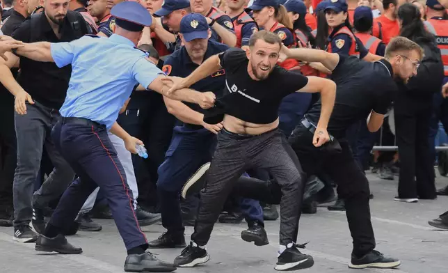 Protesters scuffle with police officers blocking a street during a demonstration in Tirana, Albania, Wednesday, June 3, 2026, opposing a luxury coastal development project linked to Jared Kushner and Ivanka Trump over concerns about environmental impacts and transparency.(AP Photo/Hameraldi Agolli)