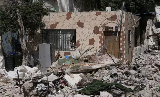 A Palestinian girl looks out a window at the rubble of a home demolished by Israeli authorities in the Silwan neighborhood of east Jerusalem, May 19, 2026. (AP Photo/Mahmoud Illean)