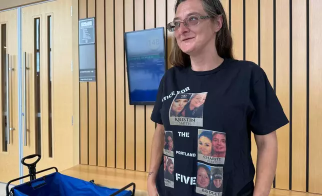 Diana Allen wears a shirt showing five women, including her daughter, Charity Perry, whom Jesse Calhoun is accused of murdering, after Calhoun was arraigned on a fifth second-degree murder charge, in Portland, Ore. on Wednesday, June 3, 2026. (AP Photo/Claire Rush)
