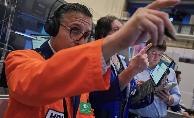 Ravi Bhandari, left, works with fellow options traders on the floor of the New York Stock Exchange, Friday, June 26, 2026. (AP Photo/Richard Drew)