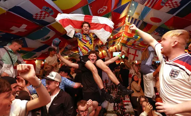England supporters celebrate during a screening of the World Cup soccer match between England and Croatia at The Clock pub in Hebburn, England, Wednesday, June 17, 2026. (AP Photo/Scott Heppell)