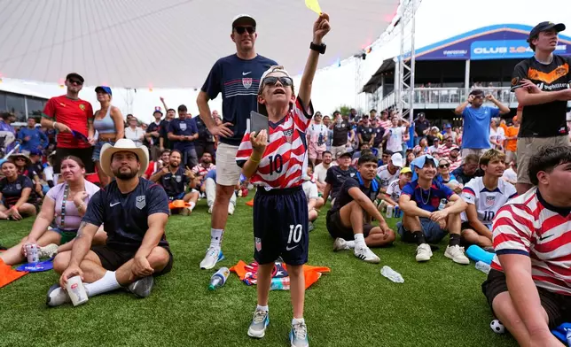 Russell Collins, 8, holds a yellow card while watching a live broadcast in Houston of a FIFA World Cup soccer match between the US and Australia, Friday, June 19, 2026. (AP Photo/Ashley Landis)