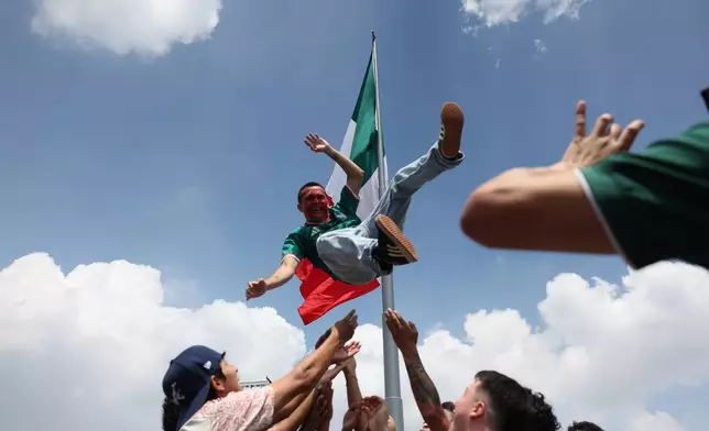 A Mexico fan is tossed into the air in celebration at a fan festival while waiting to watch a broadcast of the World Cup Group A soccer match between Mexico and South Africa in Mexico City, Thursday, June 11, 2026. (AP Photo/Sydney Shankman)