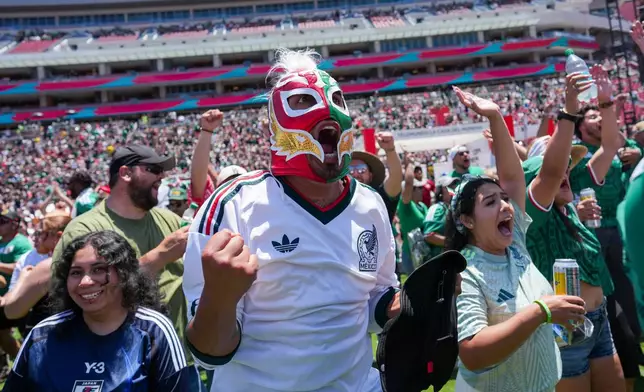 Fans celebrate a goal by Mexico while watching a live broadcast of the World Cup soccer match between Mexico and South Africa at the Los Angeles Memorial Coliseum in Los Angeles, Thursday, June 11, 2026. (AP Photo/Jae C. Hong)