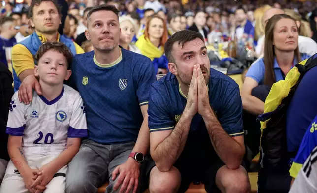 Bosnian fans react at a fan festival, Friday, June 12, 2026, in Sarajevo, Bosnia, as they watch a broadcast of the World Cup Group B soccer match between Canada and Bosnia. (AP Photo/Armin Durgut)