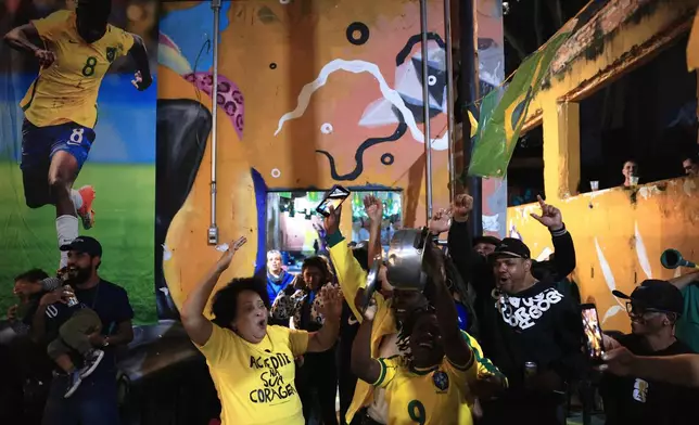 Fans celebrate a goal scored by Brazil against Morocco during a World Cup watch party at a housing occupation run by the Homeless Workers Movement, in Sao Paulo, Brazil, Saturday, June 13, 2026. (AP Photo/Ettore Chiereguini)