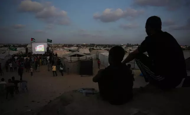 Palestinians watch a live broadcast of the World Cup soccer match between Spain and Saudi Arabia on a screen in Khan Younis, central Gaza Strip, Sunday, June 21, 2026. (AP Photo/Abdel Kareem Hana) CORRECTION: This corrects the location from Nuseirat to Khan Younis.