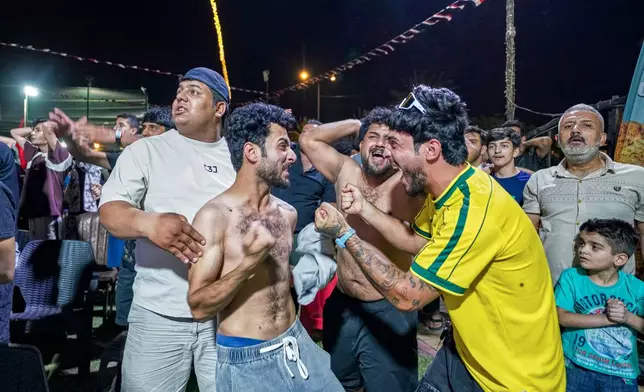 Iraqi soccer fans react after Iraq scored as they watch the World Cup match between Iraq and Norway on a large screen in downtown Baghdad, Iraq, early Wednesday, June 17, 2026. (AP Photo/Anmar Khalil)