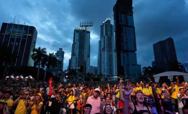 Soccer fans cheer as Pitbull performs between World Cup matches, at a public watch party at Bayfront Park in downtown Miami, Saturday, June 13, 2026. (AP Photo/Rebecca Blackwell)
