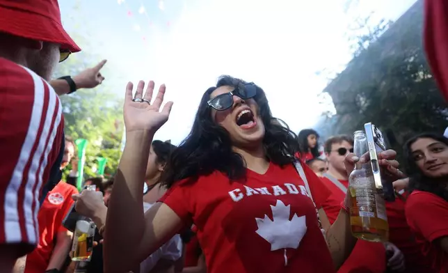 Canada fans celebrate after their team beat Qatar in the World Cup Group B soccer match in Vancouver, British Columbia, Thursday, June 18, 2026. (AP Photo/Kaleb Tatum)