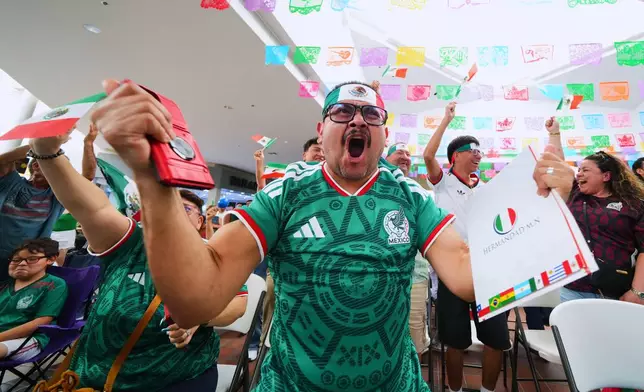 Jesus Vasquez Martinez reacts with others after Mexico's Julian Quinones scored his side's first goal on South Africa during the opening match of the FIFA World Cup soccer tournament, Thursday, June 11, 2026, as supporters gathered for a watch party in Fort Worth, Texas. (AP Photo/Julio Cortez)