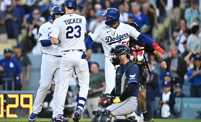 Los Angeles Dodgers' Kyle Tucker (23) is greeted by teammates after hitting a three-run home run during the second inning of a baseball game against the Tampa Bay Rays, Monday, June 15, 2026, in Los Angeles. (AP Photo/William Liang)