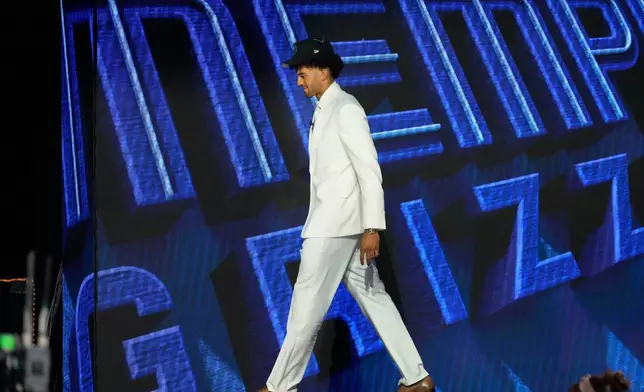 Cameron Boozer gestures as he walks off the stage after being chosen by the Memphis Grizzlies in the first round of the NBA basketball draft, Tuesday, June 23, 2026, in New York. (AP Photo/Yuki Iwamura)
