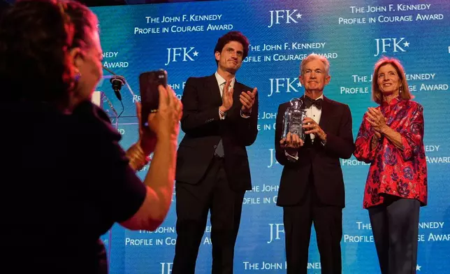 Federal Reserve Board Governor Jerome Powell, the former Federal Reserve chair, center, stands with former ambassador Caroline Kennedy, right, and her son Jack Schlossberg, as Powell's wife Elissa Leonard takes a picture at left, while being honored with the Profile in Courage Award at the John F. Kennedy Presidential Library, Sunday, May 31, 2026, in Boston. (AP Photo/Charles Krupa)