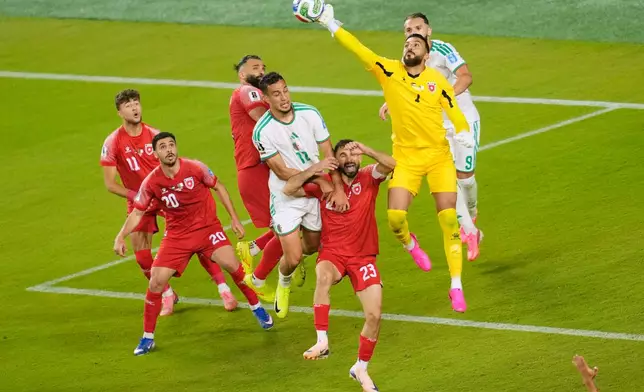 Jordan goalkeeper Yazeed Abulaila (1) makes a save as Algeria's Nadhir Benbouali (12) attacks during the World Cup Group J soccer match between Jordan and Algeria in Santa Clara, Calif., near San Francisco, Monday, June 22, 2026. (AP Photo/Jeff Chiu)
