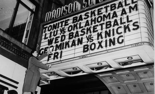FILE - George Mikan of the Minneapolis Lakers polishes off the sign on the marquee of Madison Square Garden in New York, Dec. 13, 1949, to make sure his name shines brightly for tomorrow's game. (AP Photo/Jacob Harris, File)