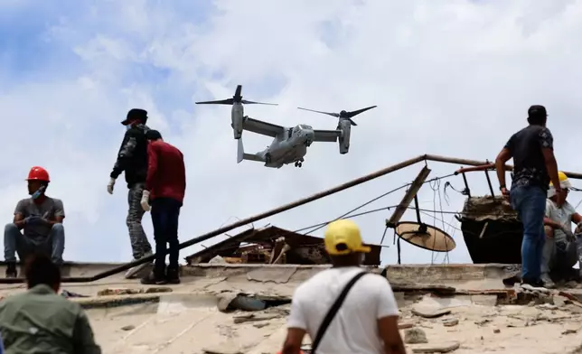 A U.S. aircraft flies over an area struck by earthquakes in La Guaira, Venezuela, Sunday, June 28, 2026. (AP Photo/Pedro Mattey)