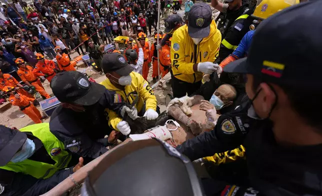 Rescue workers carry a mans rescued from the rubble of a building that collapsed in the earthquakes that struck La Guaira, Venezuela, Sunday, June 28, 2026. (AP Photo/Matias Delacroix)