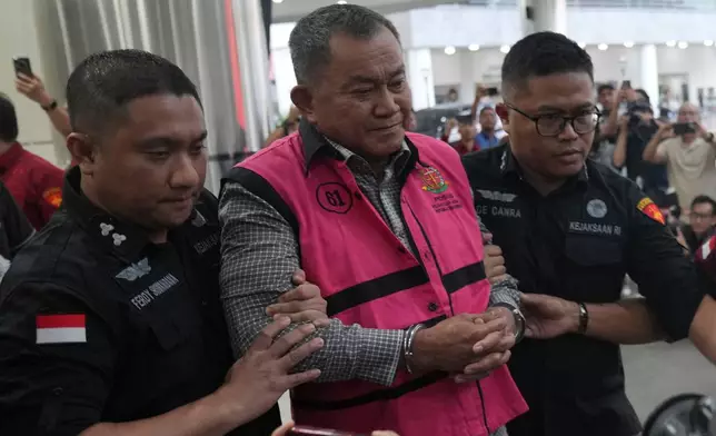 Former deputy head of Indonesia's National Nutrition Agency Lodewyk Pusung, center, is escorted by prosecutors to a waiting detention car after being named as a corruption suspect, at the Attorney Genera's Office in Jakarta, Indonesia, Wednesday, June 3, 2026. (AP Photo/Achmad Ibrahim)