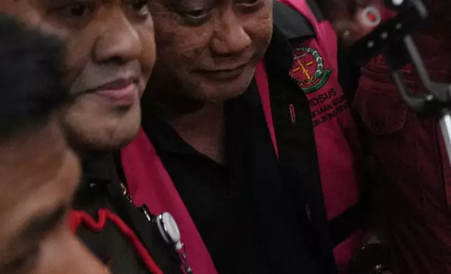 Former head of Indonesia's National Nutrition Agency Dadan Hindayana, center, is escorted by prosecutors to a waiting detention car after being named as a corruption suspect, at the Attorney Genera's Office in Jakarta, Indonesia, Wednesday, June 3, 2026. (AP Photo/Achmad Ibrahim)