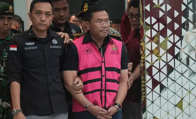 Former deputy head of Indonesia's National Nutrition Agency Sony Sonjaya, center, is escorted by prosecutors to a waiting detention car after being named as a corruption suspect, at the Attorney Genera's Office in Jakarta, Indonesia, Wednesday, June 3, 2026. (AP Photo/Achmad Ibrahim)