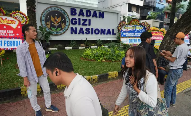 People walk past the office of the National Nutrition Agency as it is being searched by prosecutors, in Jakarta, Indonesia, Wednesday, June 3, 2026. (AP Photo/Dita Alangkara)
