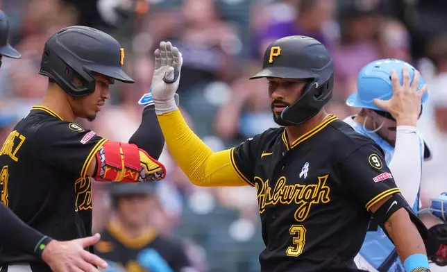 Pittsburgh Pirates' Endy Rodríguez, left, congratulates Nick Gonzales (3) who crosses home plate after hitting a two-run home run off Colorado Rockies starting pitcher Michael Lorenzen in the fourth inning of a baseball game Sunday, June 21, 2026, in Denver. (AP Photo/David Zalubowski)