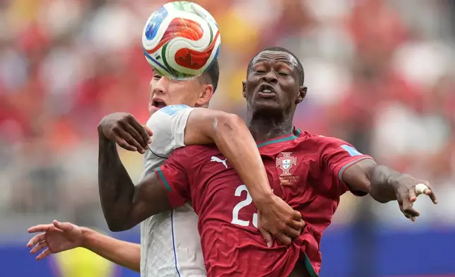 Portugal's Nuno Mendes (25), right, challenges for the ball with Uzbekistan's Behruzjon Karimov (24) during the World Cup Group K soccer match between Portugal and Uzbekistan in Houston, Tuesday, June 23, 2026. (AP Photo/Eric Gay)