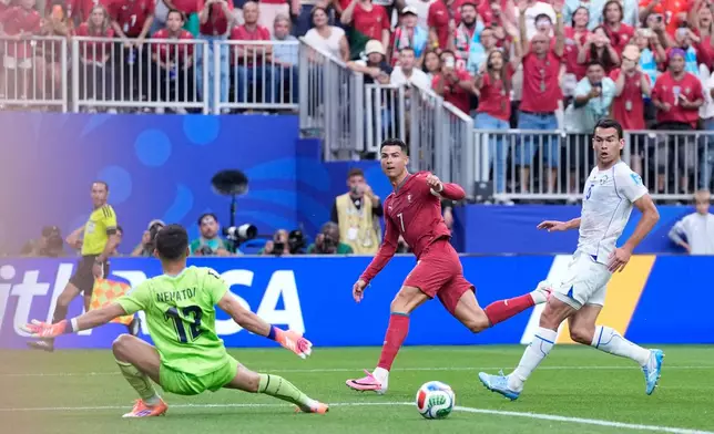 Portugal's Cristiano Ronaldo scores his side's third goal past Uzbekistan goalkeeper Abduvohid Nematov during the World Cup Group K soccer match between Portugal and Uzbekistan in Houston, Tuesday, June 23, 2026. (AP Photo/Ashley Landis)