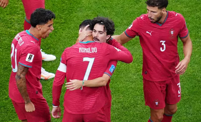 Portugal's Vitinha embraces Portugal's Cristiano Ronaldo (7) after Ronaldo scored a goal during the World Cup Group K soccer match between Portugal and Uzbekistan in Houston, Tuesday, June 23, 2026. (AP Photo/Karen Warren)