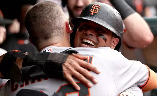 San Francisco Giants' Matt Chapman, back to camera, celebrates hitting a grand slam with Luis Arraez during the fourth inning of a baseball game against the Chicago Cubs at Wrigley Field, Friday, June 5, 2026, in Chicago. (AP Photo/Geoff Stellfox)